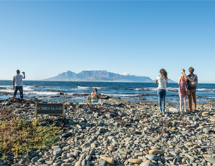 People overlooking the sea & Table Mountain